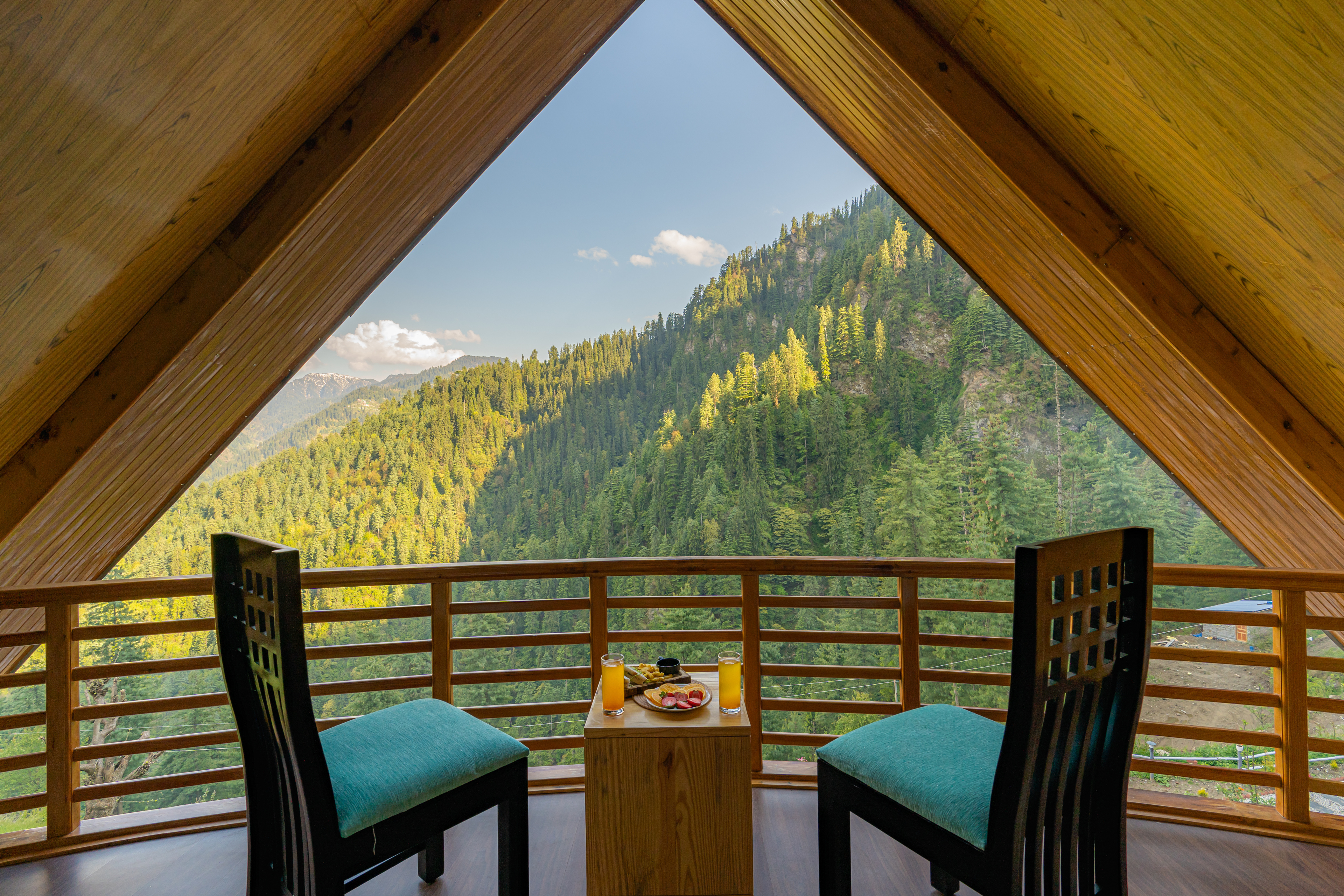 Breakfast table for two on the balcony, mountains framed by the A of the roof