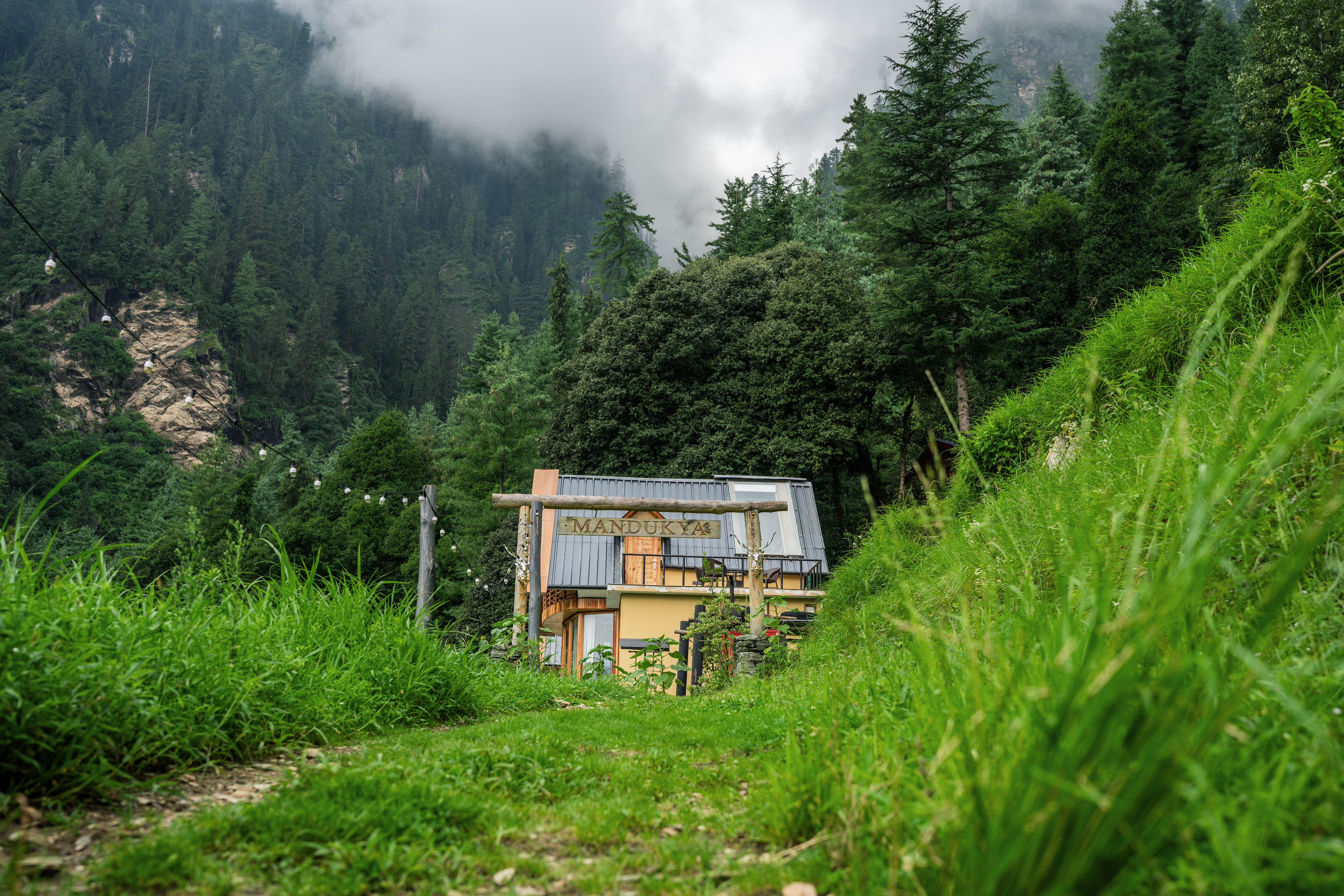Monsoon mist rolling over the green hillside path to Mandukya